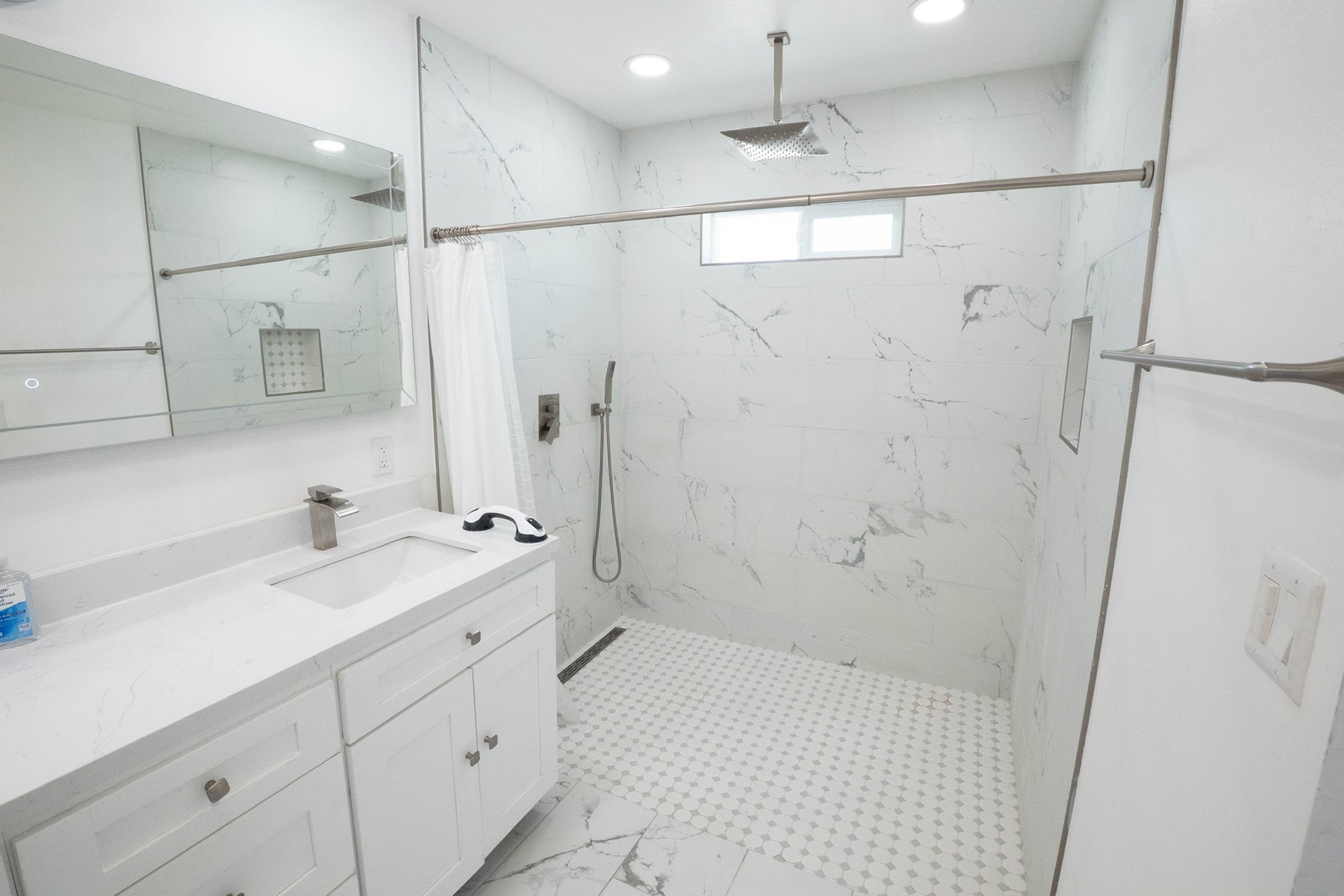 Clean, bright bathroom with a walk-in shower and non-slip tile flooring for resident safety