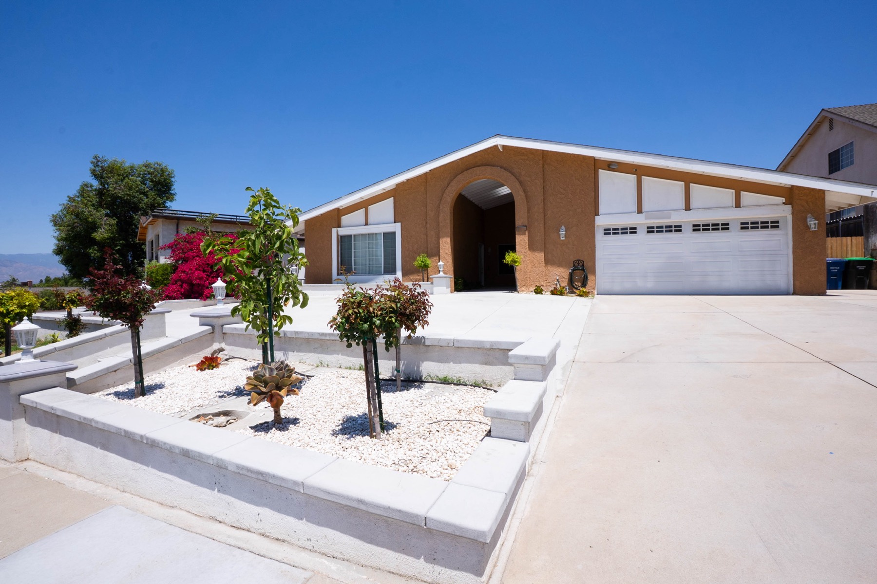 The Vibrant Life Home Care residential care home in Loma Linda, with blooming bougainvillea and a welcoming arched entry