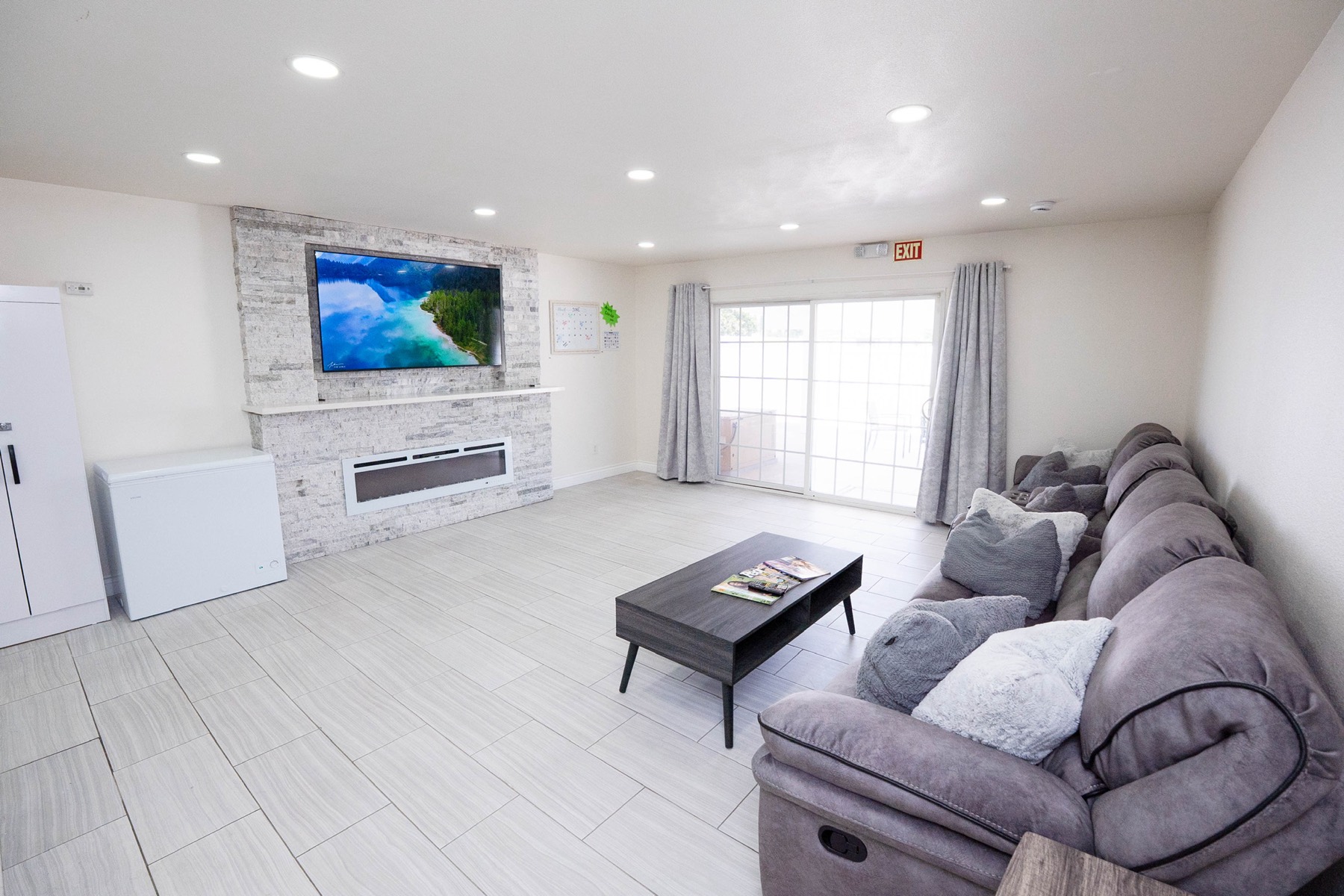 Cozy living room with a television, soft rug, and sofa seating for residents to gather together